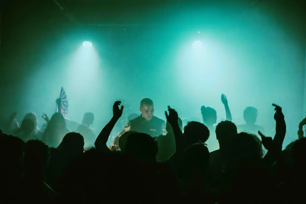 Audience at ÄGAPĒ event with red stage lighting
